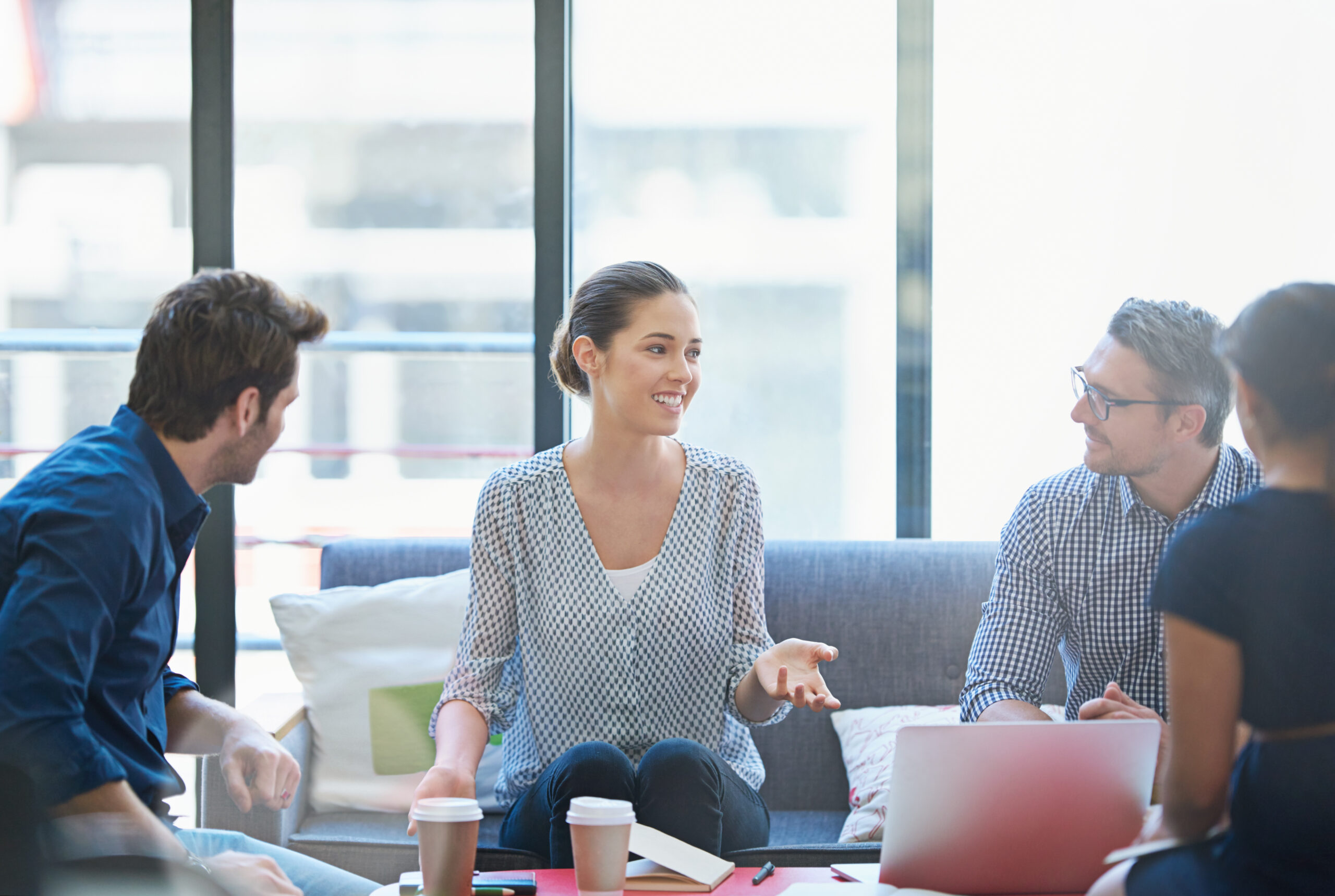 Image of woman lecturing a group of people at a conference table