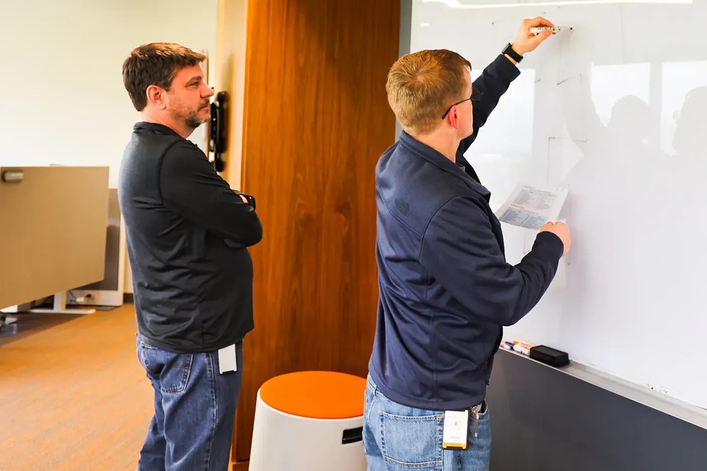 Strengthened Cybersecurity Resilience Two men working at a whiteboard.